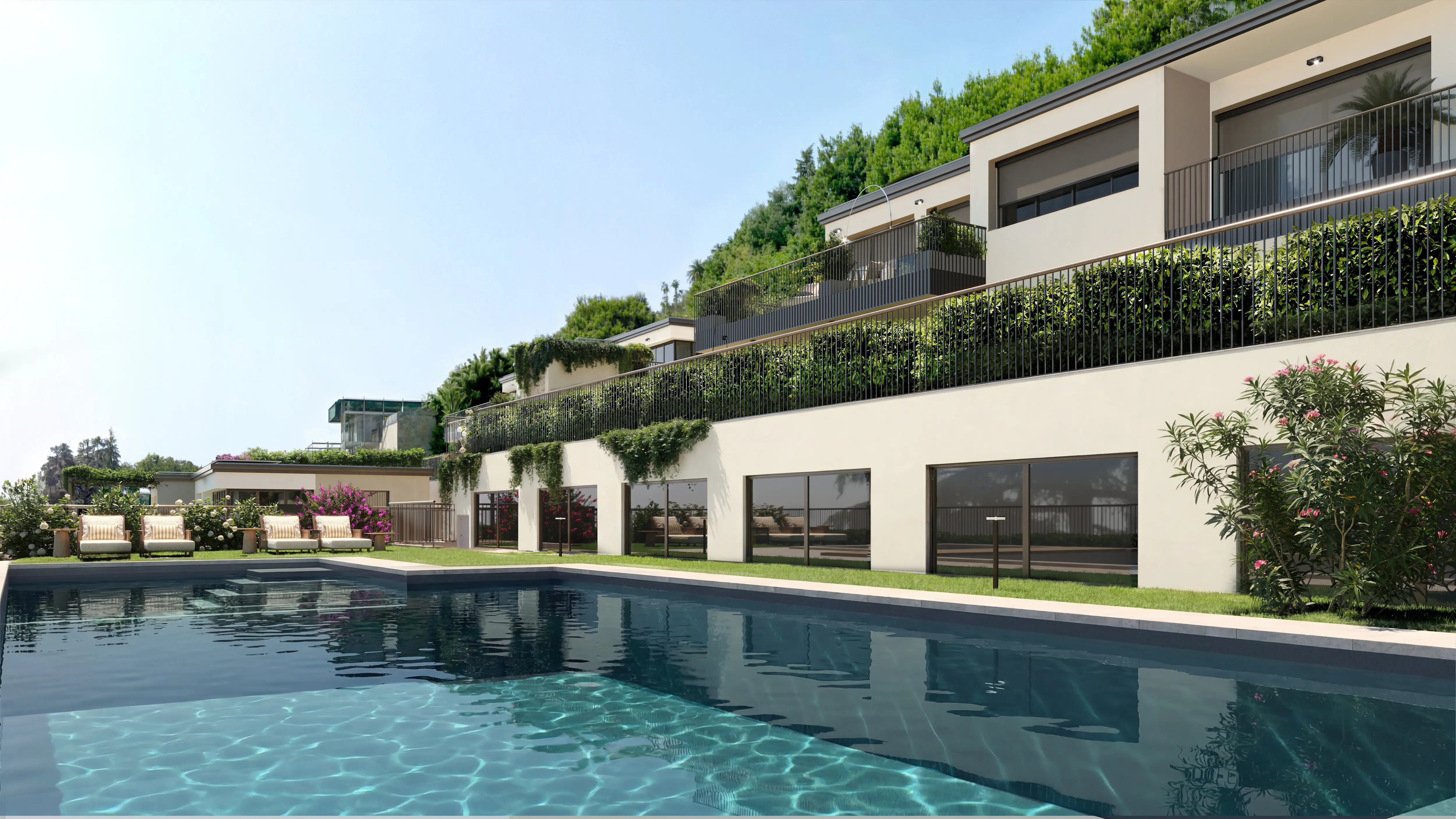 Modern multi-unit residential building with balconies, surrounded by greenery, overlooking a rectangular swimming pool and lounge chairs.